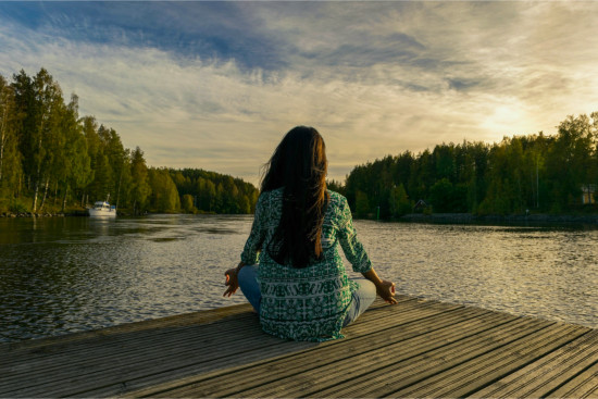 Musique de méditation passive - femme assise sur le ponton, détendue, en train de méditer